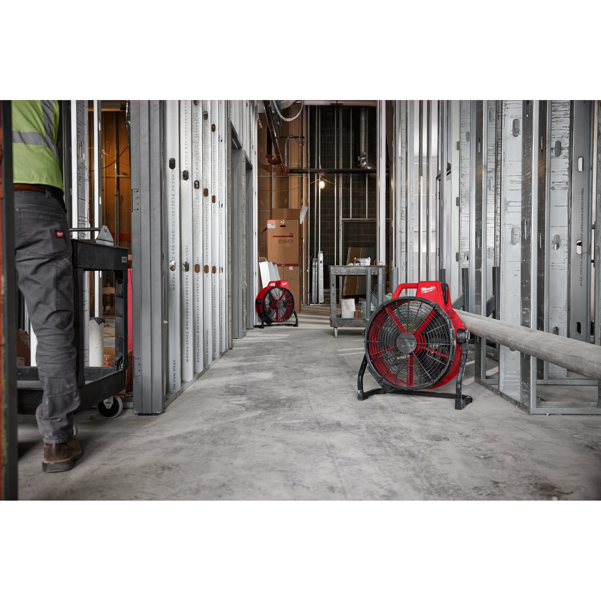 Worker using two M18 Brushless fans on the jobsite