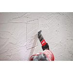 Worker using the NITRUS CARBIDE Extreme Materials Universal Fit OPEN-LOK Multi-Tool Blade to cut through plaster