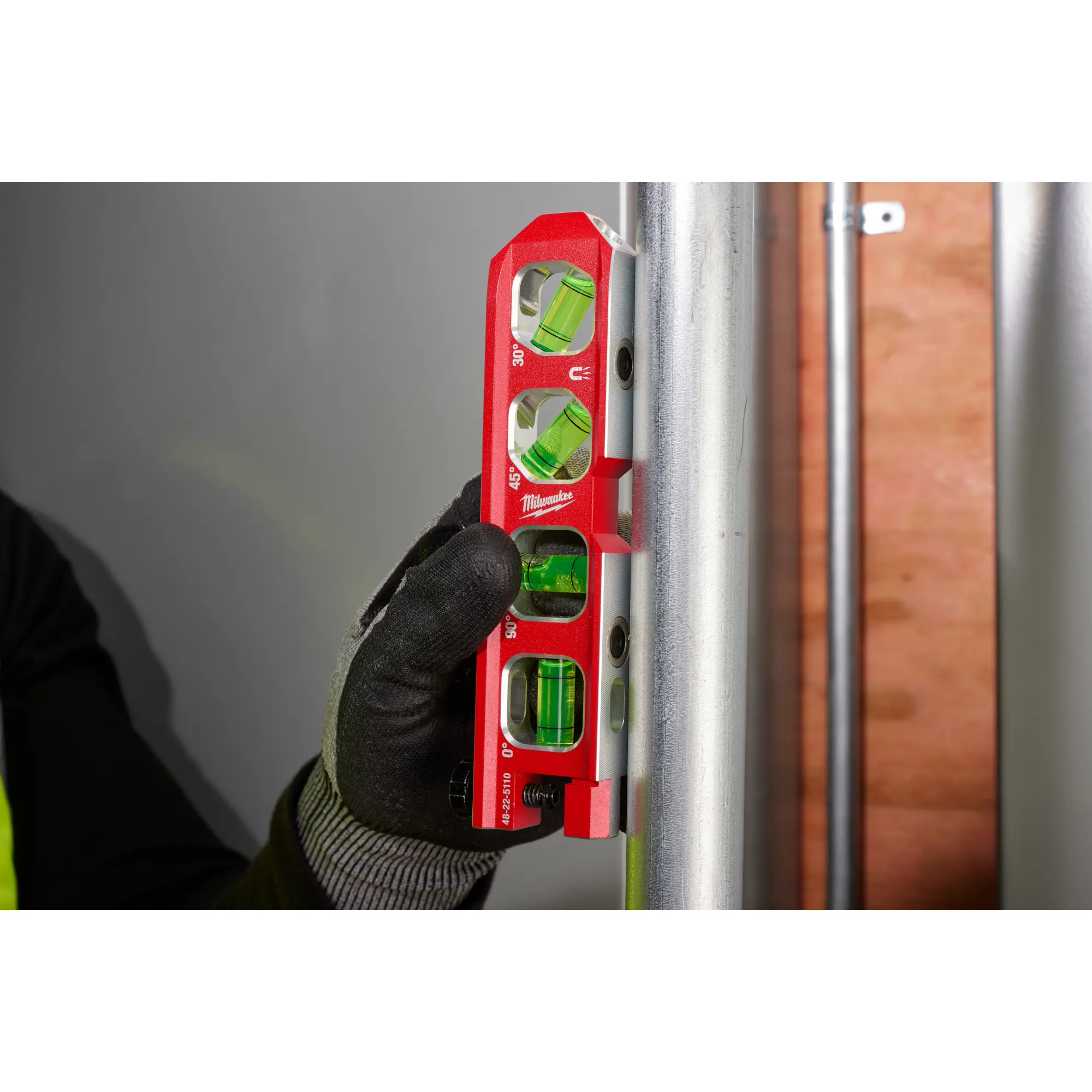 Image of the Milwaukee 6.5” Pipe Lock Billet Torpedo Level being used by a worker on a jobsite