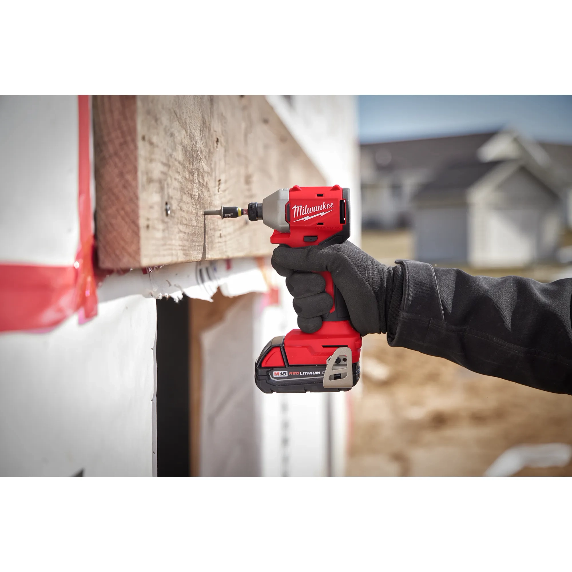 Worker using the Compact Brushless 1/4" Hex Impact Driver to drive a screw into wood