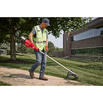 Image of a worker using the Milwaukee M18 FUEL 17” Dual Battery String Trimmer