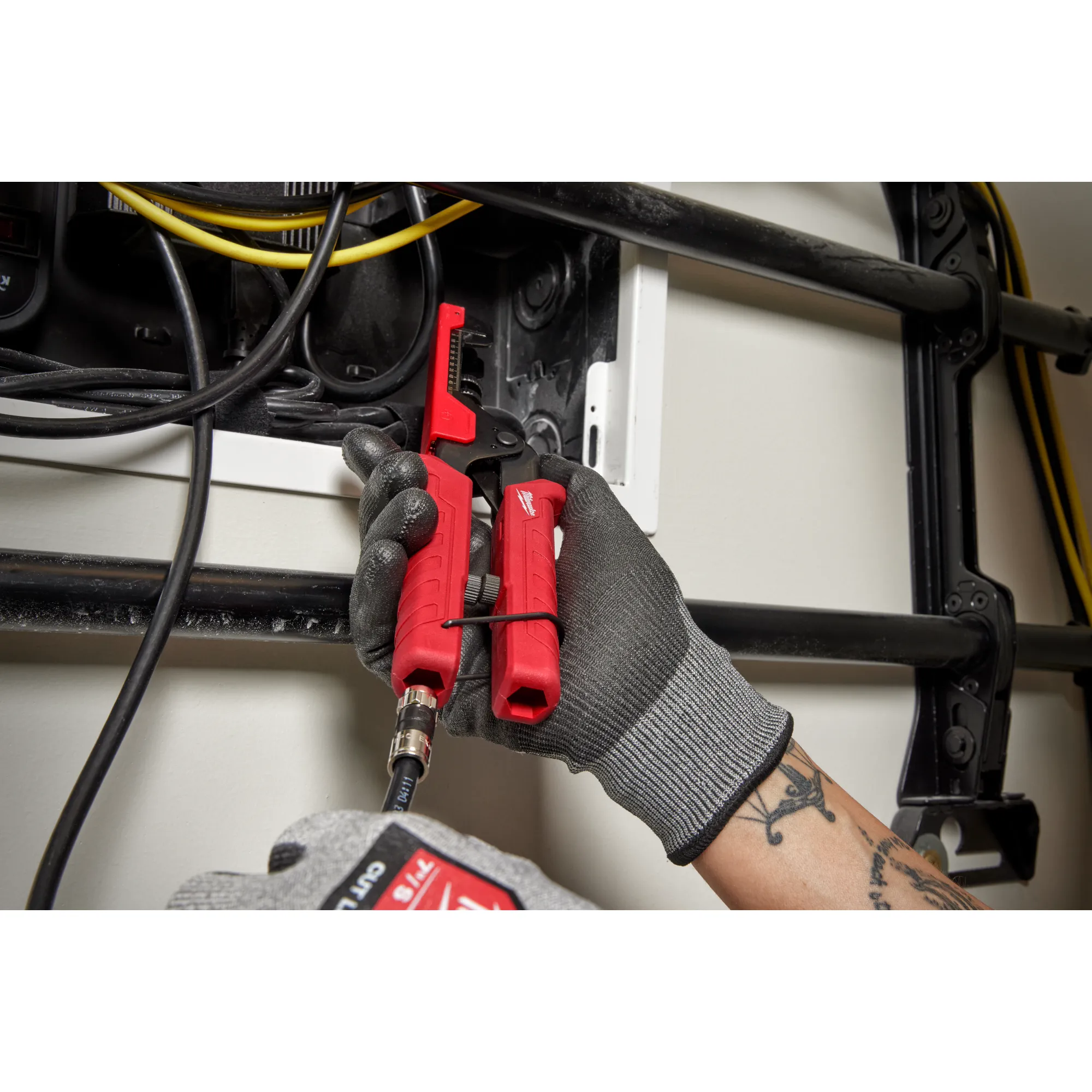 Worker using the Milwaukee Extended Reach Compression Coax Crimper for hard to reach areas