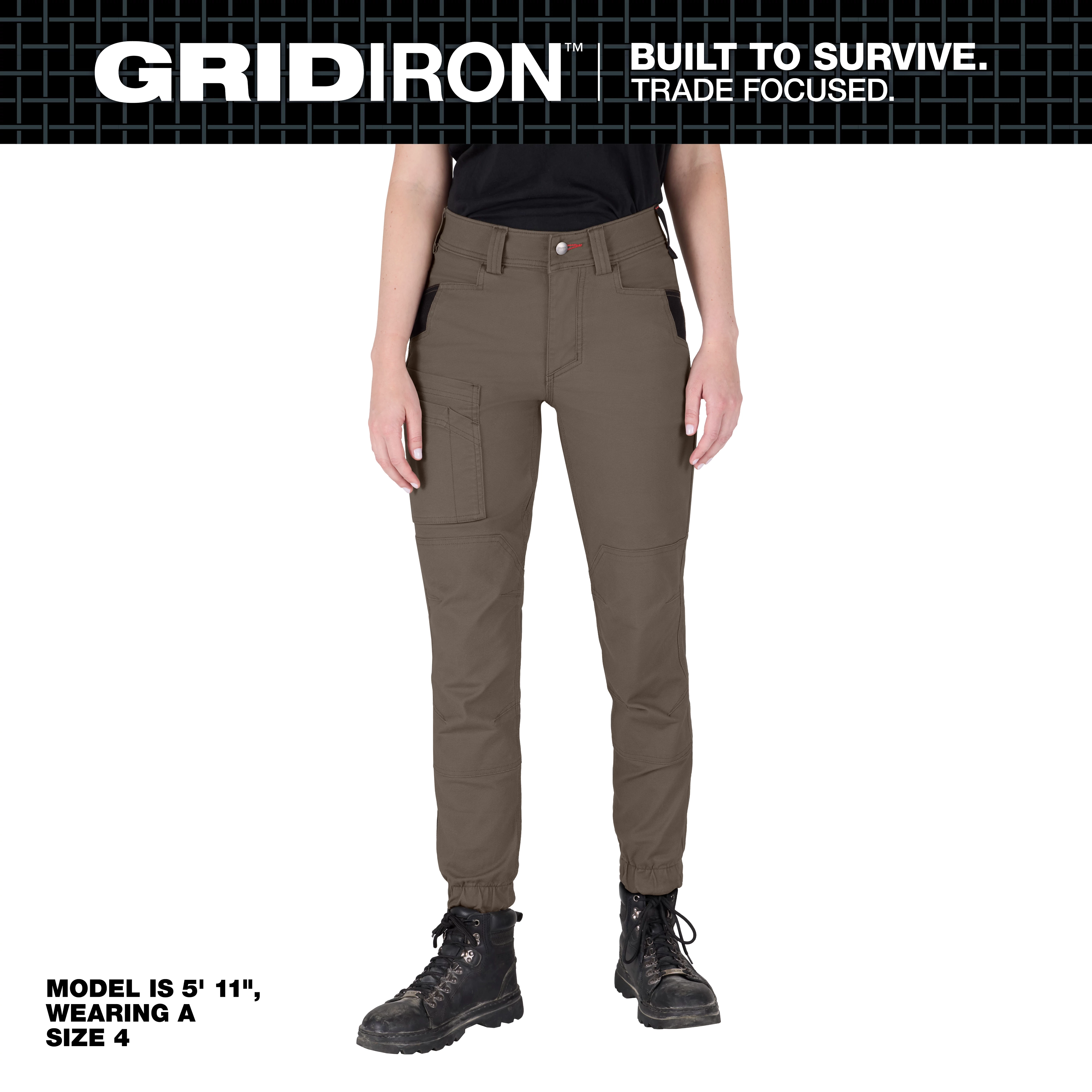 A woman is wearing Women's GRIDIRON Double Knee Jogger Pants in brown. The model is 5' 11" and is wearing a size 4. The pants feature multiple pockets and reinforced knee panels. The brand slogan "BUILT TO SURVIVE. TRADE FOCUSED." is displayed at the top.