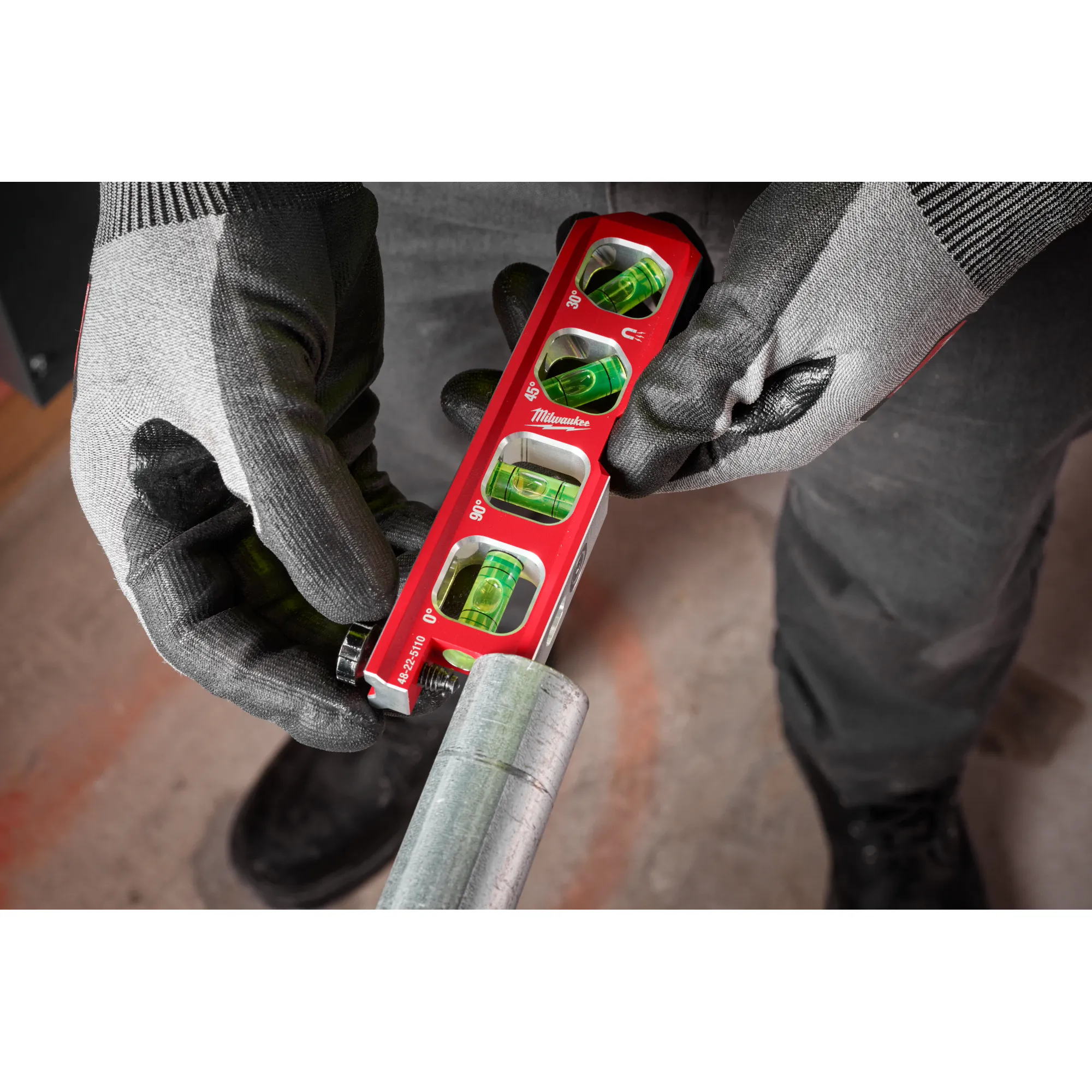 Image of the Milwaukee 6.5” Pipe Lock Billet Torpedo Level being used by a worker on a jobsite