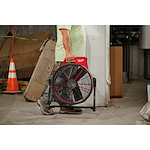 Worker carrying the jobsite fan by its handle for easy transportation